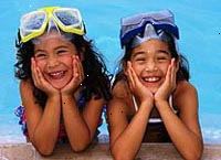 Immagine di due giovani ragazze ridacchiando dal lato della piscina