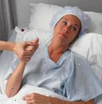 Immagine di una donna, in difficoltà, in un letto d'ospedale