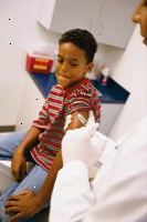 Foto di un giovane ragazzo prepara per ottenere un colpo di vaccinazione dal suo medico