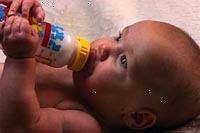 Immagine di un bambino di alimentazione se stesso una bottiglia