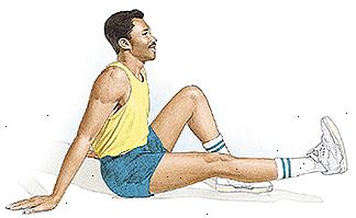 L'uomo seduto sul pavimento con un ginocchio piegato e piede piatto sul pavimento. Altra gamba è dritta e in parte sollevato da terra.