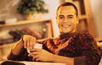 Immagine di un giovane uomo sorridente, con una tazza di caffè