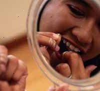 Immagine di una giovane ragazza filo interdentale i denti