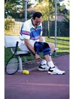 Immagine di un uomo che indossa un ginocchio-brace, giocare a tennis