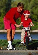 Immagine di un padre che insegna al suo giovane figlio come andare in bicicletta