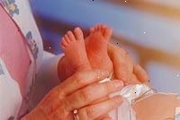 Immagine di un infermiere esaminando un neonato