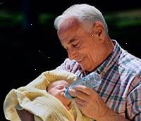 Immagine di un nonno possesso di suo nipote appena nato, lui una bottiglia di alimentazione
