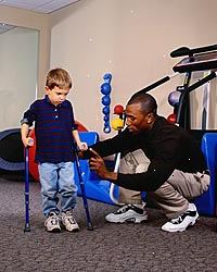 Immagine di giovane ragazzo, con le canne, durante una sessione di terapia fisica